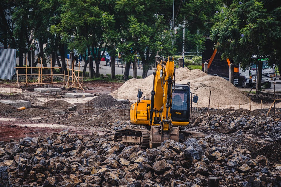 Koparka pracująca na placu budowy podczas przygotowania terenu pod fundamenty