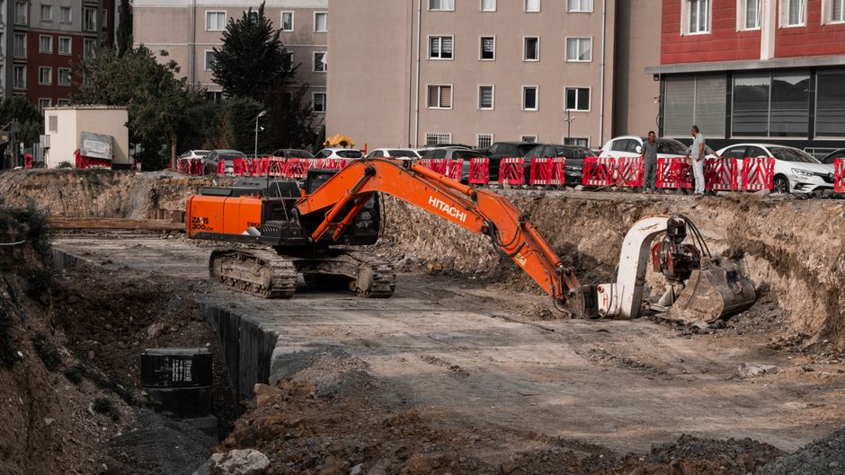 operator nowoczesnej koparki gąsienicowej wykonujący precyzyjny wykop pod kanalizację na placu budowy