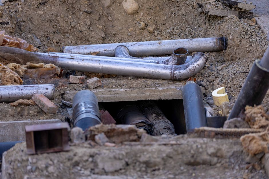 pracownik nadzorujący głęboki wykop pod przyłącze elektryczne z wykorzystaniem profesjonalnego sprzętu budowlanego